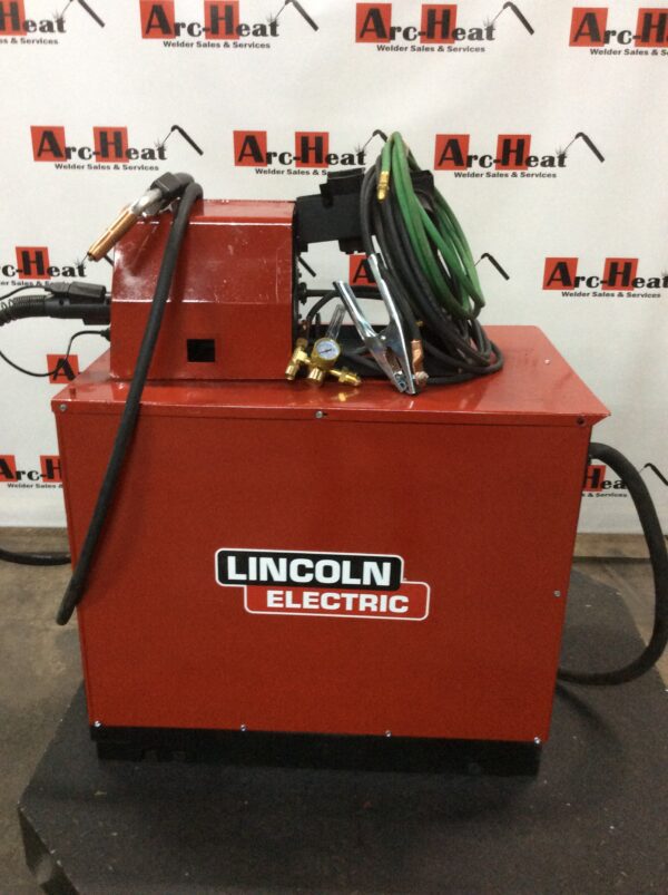 A lincoln electric wire feeder sitting on top of a red box.