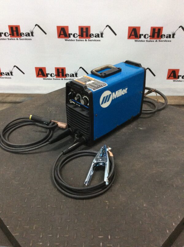 A blue welding machine sitting on top of a floor.