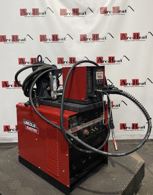 Red welding machine with cables and hoses.