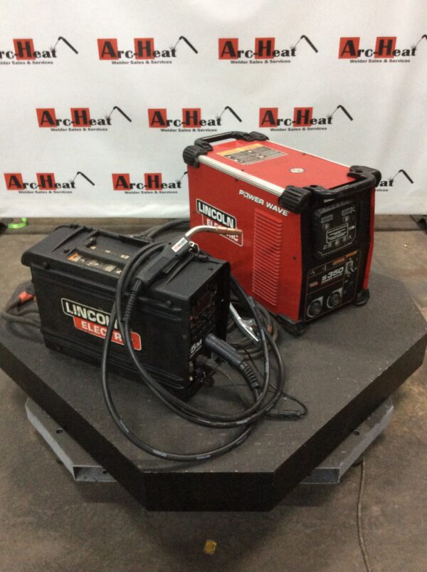 A couple of welding machines sitting on top of a table.