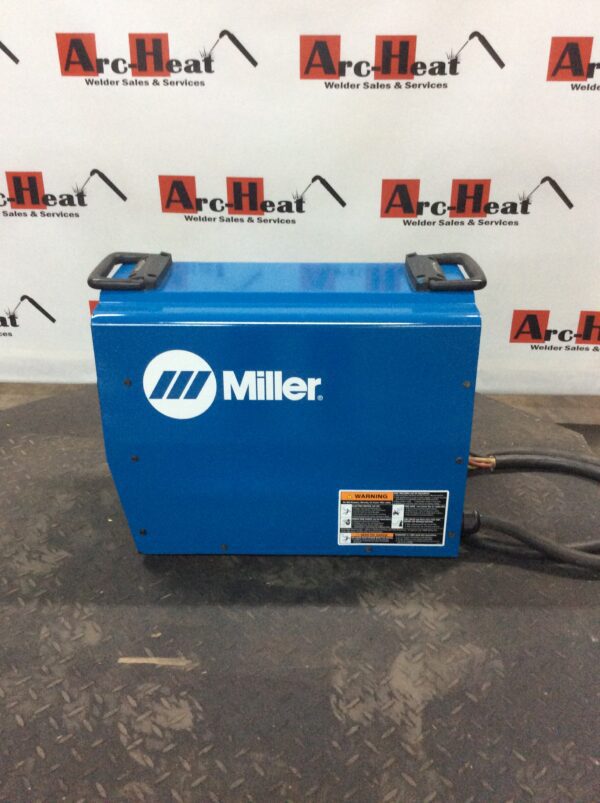 A miller electric welding machine is sitting on the floor.