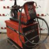 A red and black machine on display in front of a wall.
