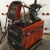 A red machine with a hose attached to it.
